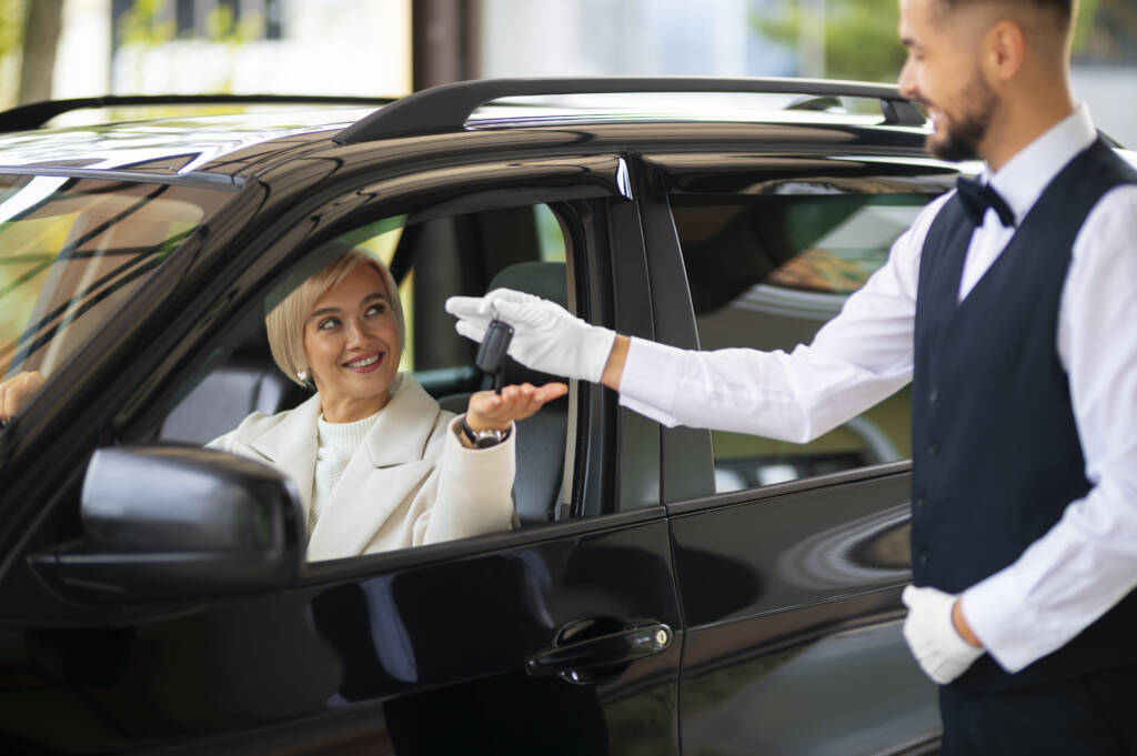 woman exchanging car keys with parking valet